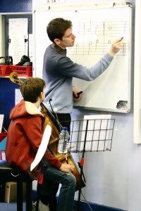 Two boys learning music at a whiteboard